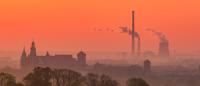 Sunset photo of a cathedral a distant power plant
